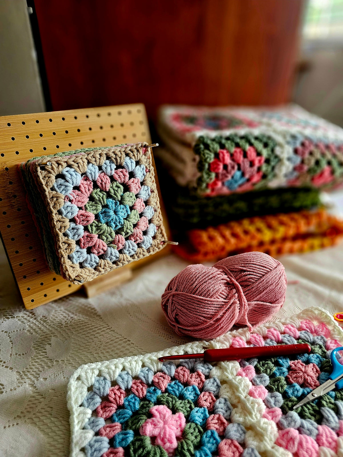 A crocheted blanket and a crochet kit on a bed