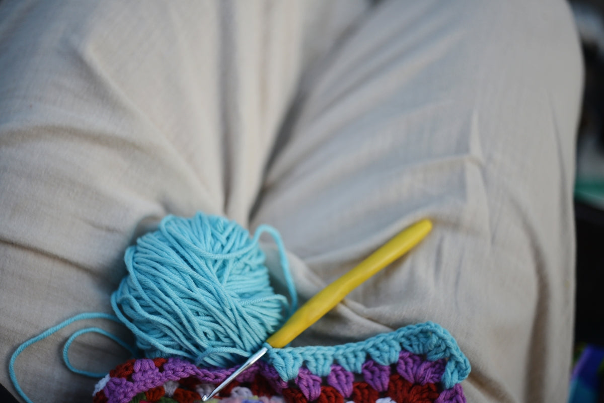 Crocheting with blue yarn is in progress.