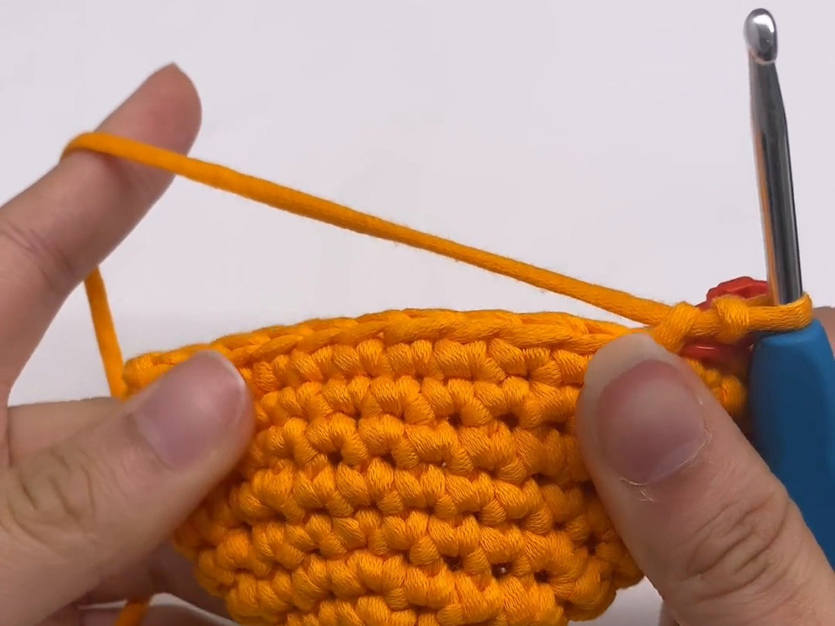 Showing the right side of an amigurumi piece, with its neat rows of V-shaped stitches